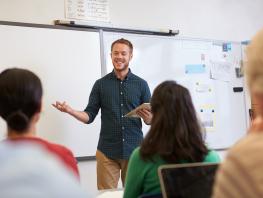 A male teacher standing in front of adult learners at the City of Glasgow College 