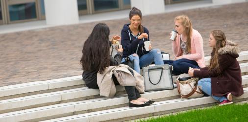 Students drinking coffee in the courtyard at Riverside campus.